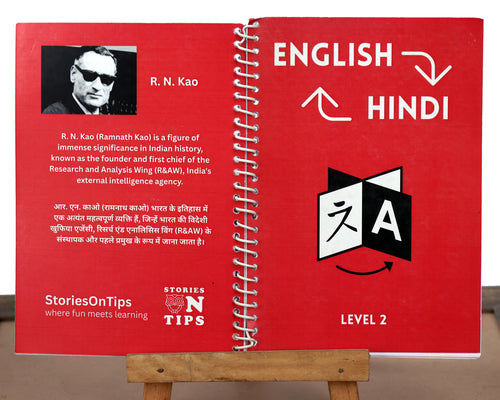 Red bilingual book with English and Hindi text on a stand