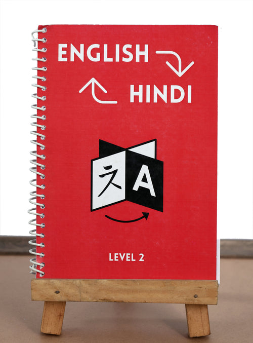 Red notebook with English to Hindi text and a logo on a wooden stand