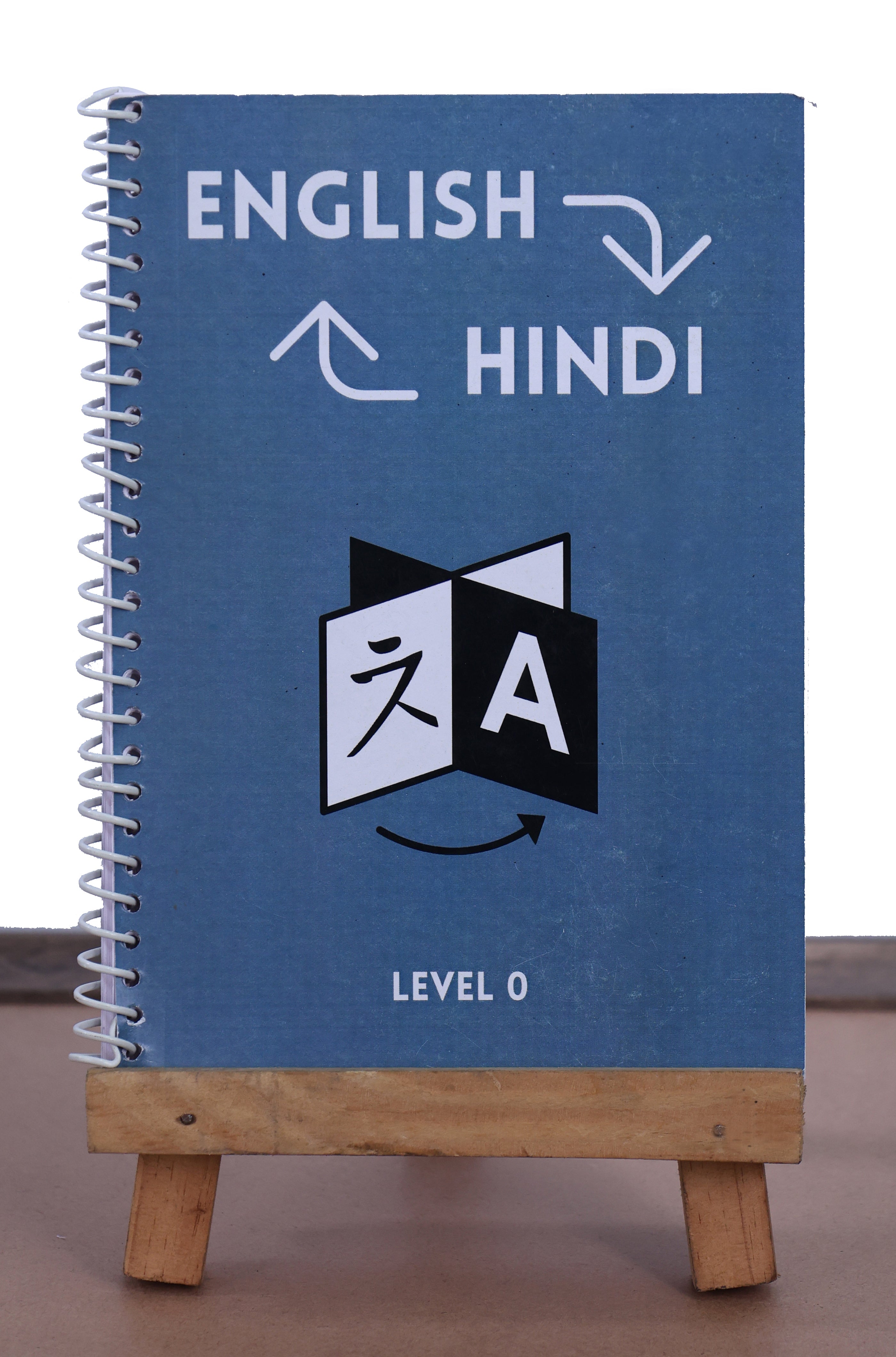 Blue notebook with English to Hindi translation symbols on a wooden stand